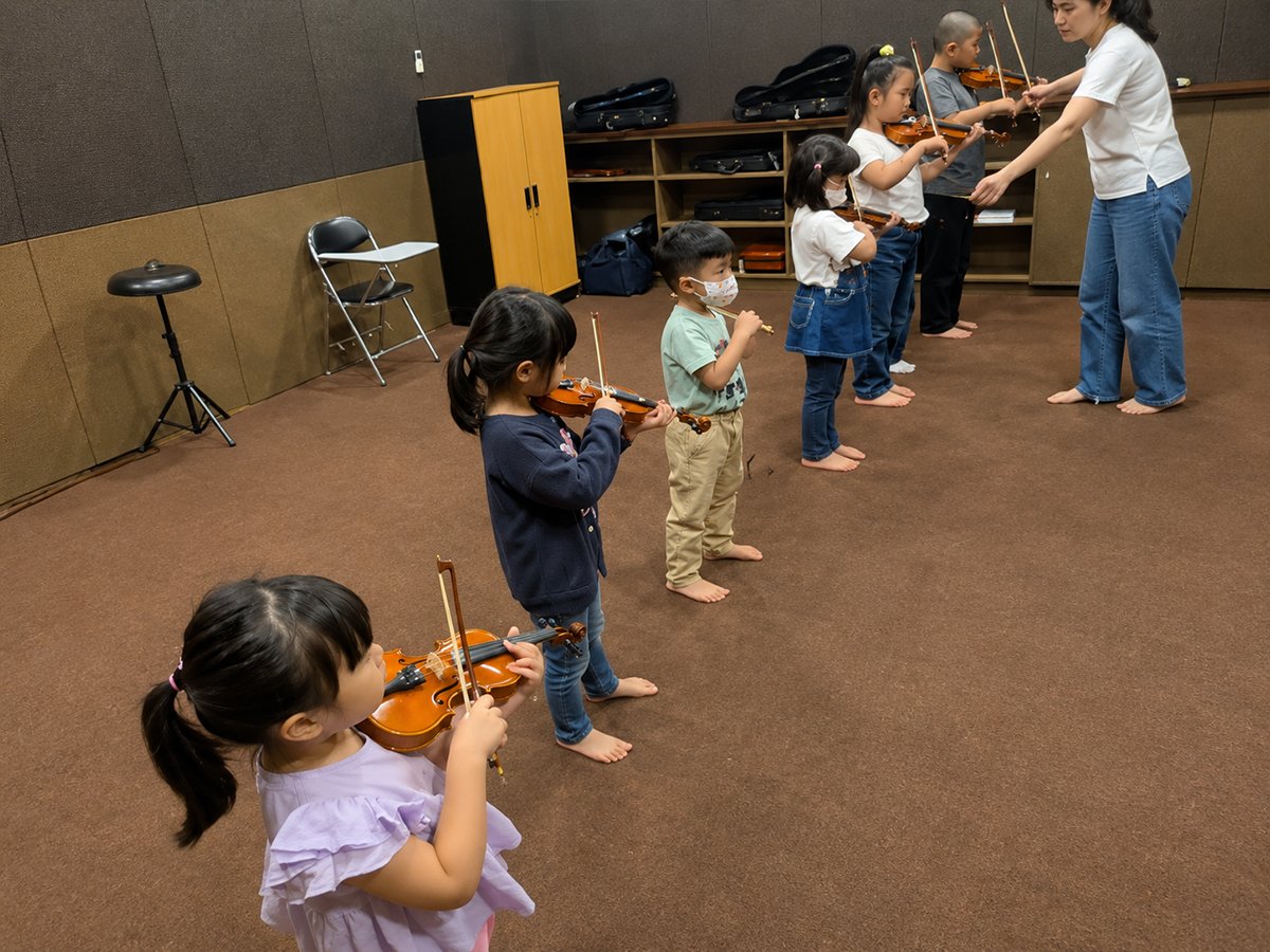 Children learning violin with teachers at Cordana Music School Intercon